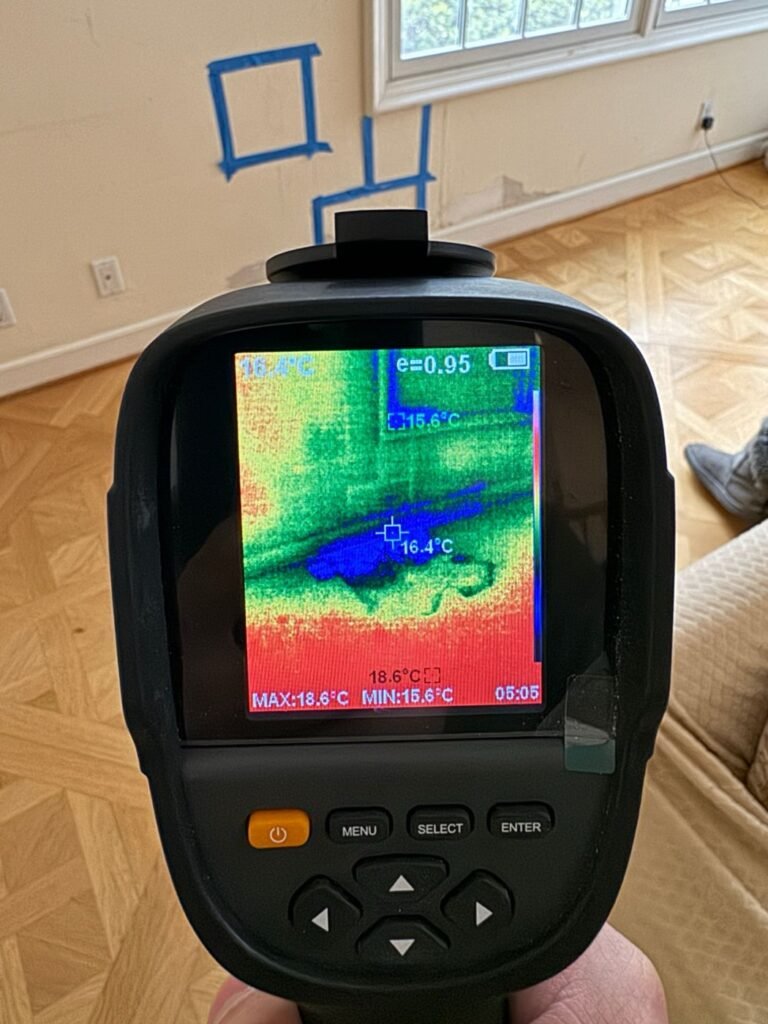 Thermal camera showing hidden moisture in the wall and floor under a window in a Bel Air home