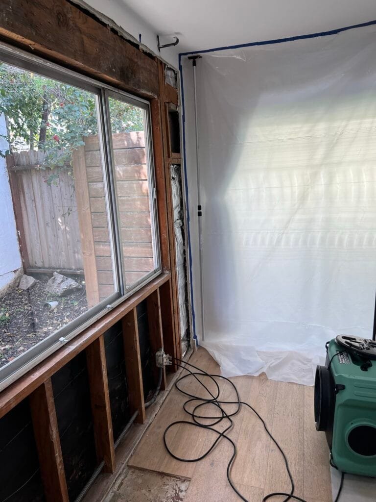 Wall opened under a leaking window during mold remediation in a Beverly Hills home