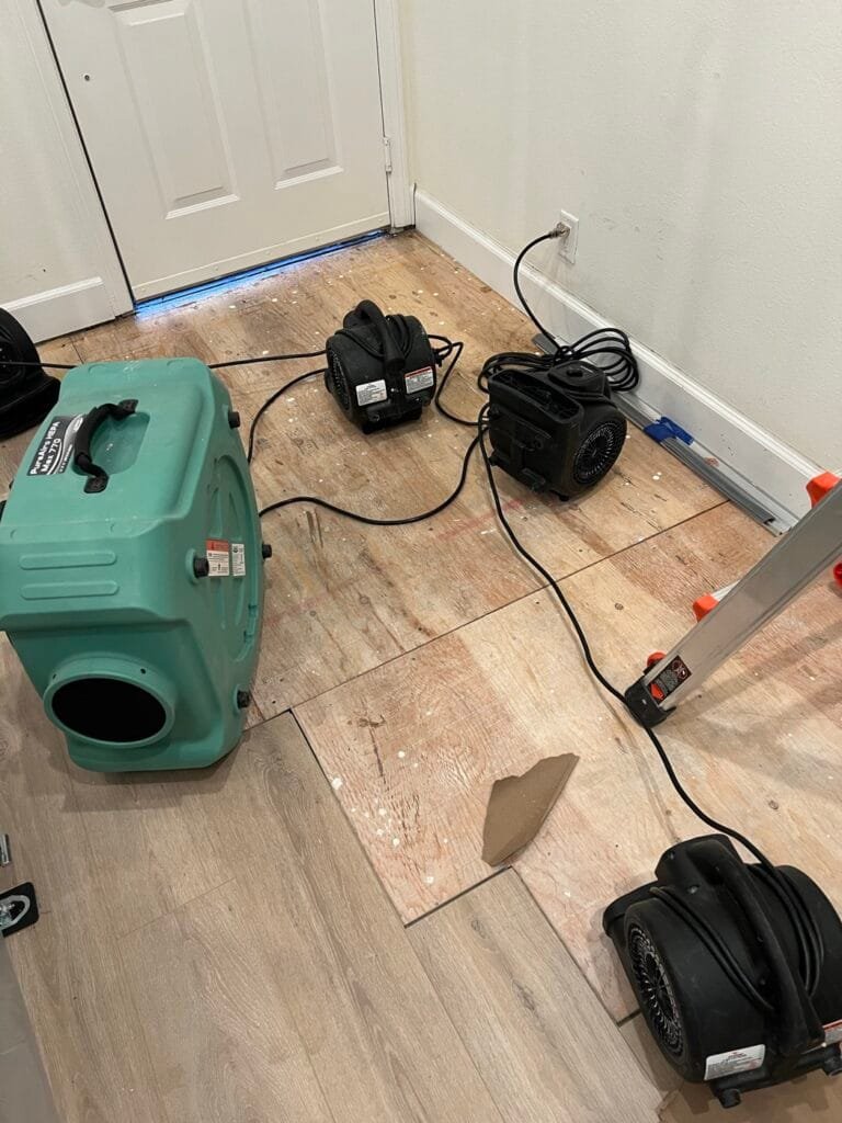Air movers and an air scrubber drying the subfloor after a drain leak in a Calabasas home