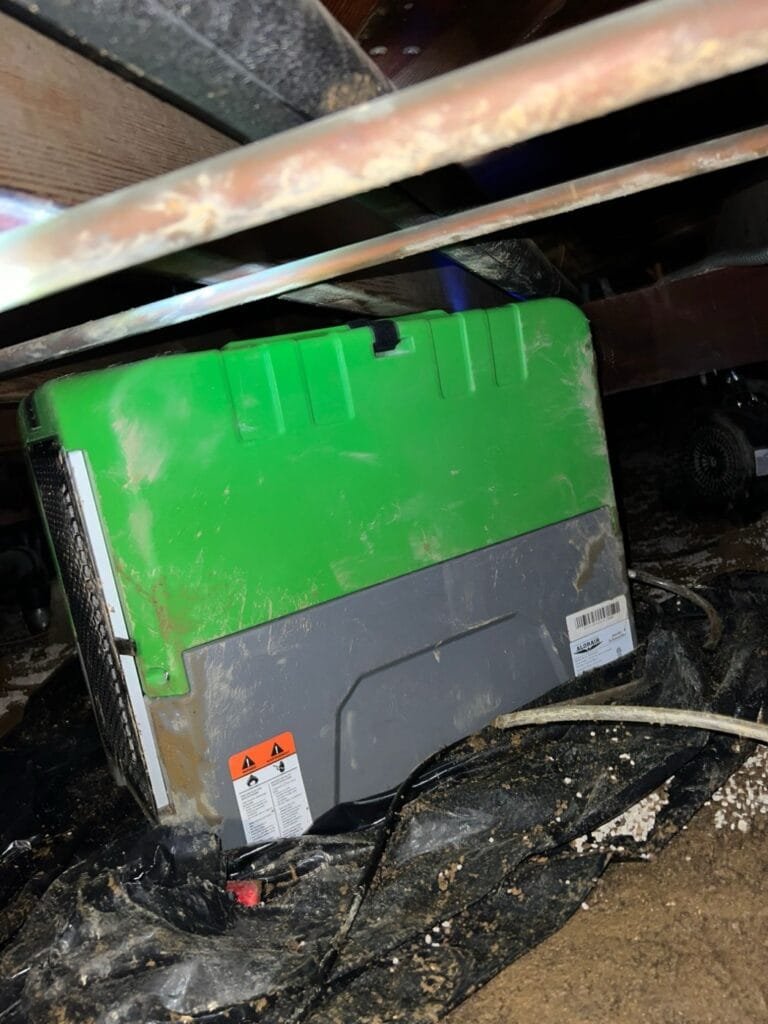 Dehumidifier set up in a flooded crawl space under a Culver City home after hillside rain