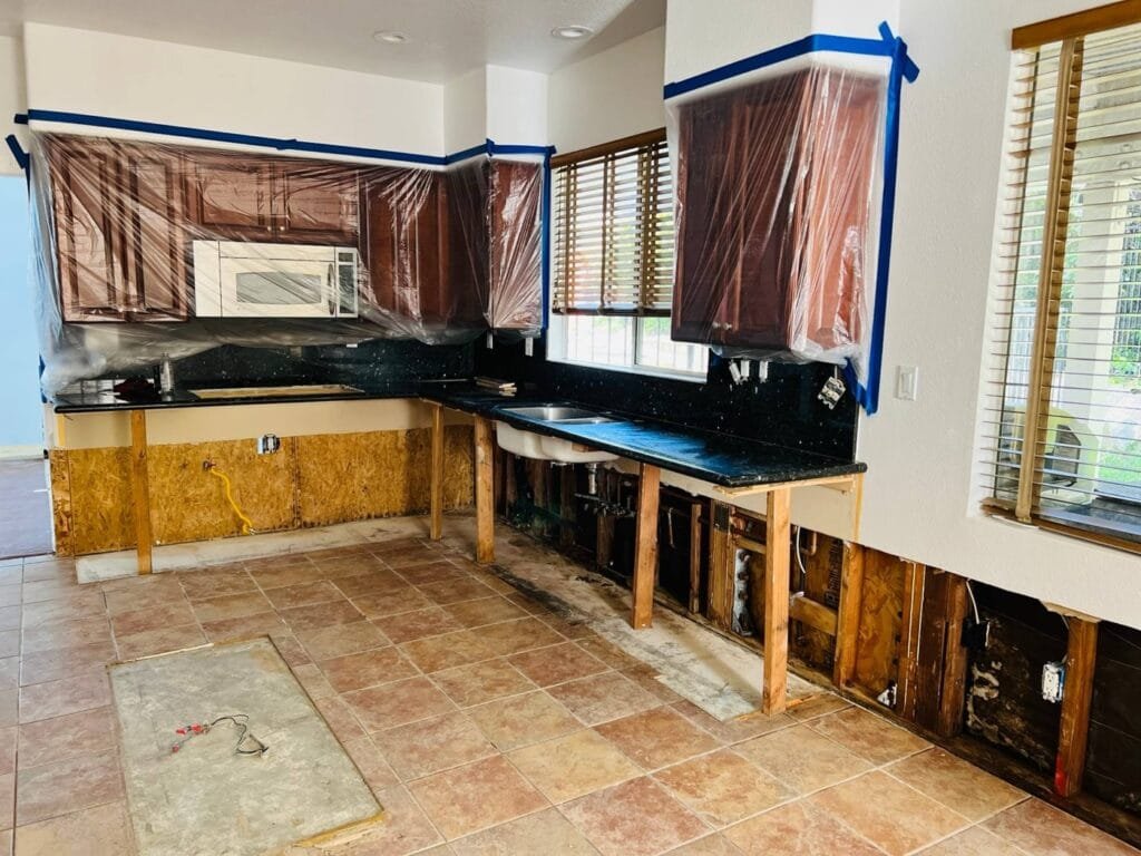 Countertop supported in place while base cabinets are removed and the kitchen is dried in a Santa Clarita home