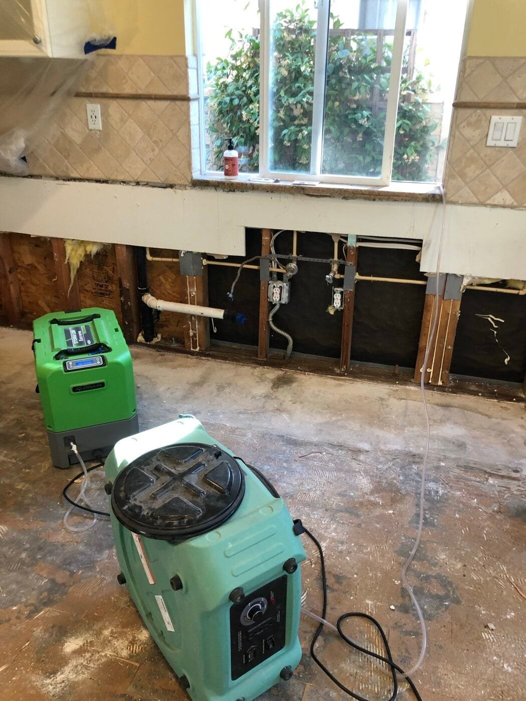 Dehumidifier and HEPA air scrubber drying a kitchen after a dishwasher leak in Santa Clarita